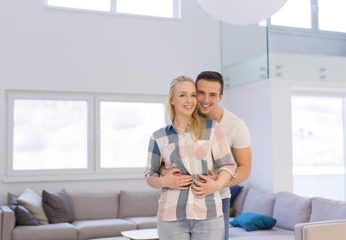 Portrait of a happy young beautiful couple hugging in their new home