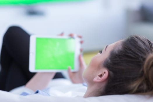 young happy woman on sofa using tablet computer at luxury home