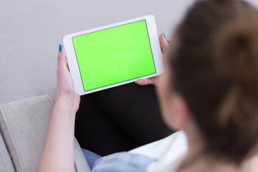 young happy woman on sofa using tablet computer at luxury home