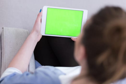 young happy woman on sofa using tablet computer at luxury home