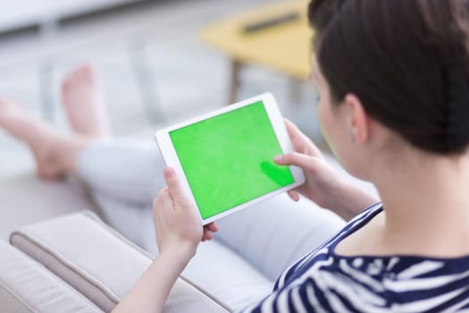 young happy woman on sofa using tablet computer at luxury home