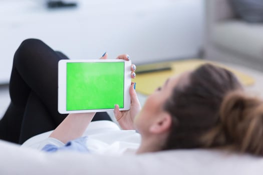 young happy woman on sofa using tablet computer at luxury home