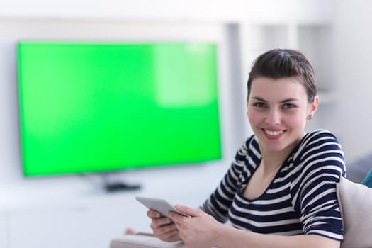 young happy woman on sofa using tablet computer at luxury home