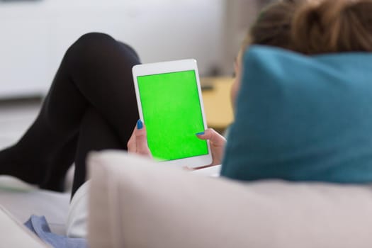 young happy woman on sofa using tablet computer at luxury home