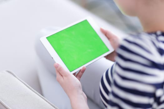 young happy woman on sofa using tablet computer at luxury home