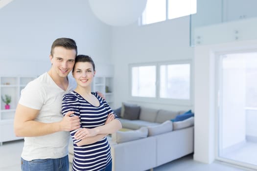 Portrait of a happy young beautiful couple hugging in their new home