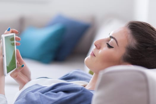 young happy woman on sofa using tablet computer at luxury home