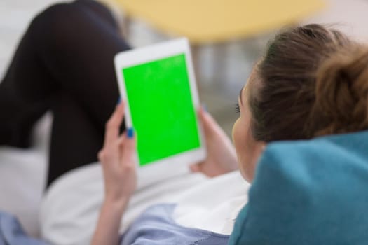 young happy woman on sofa using tablet computer at luxury home