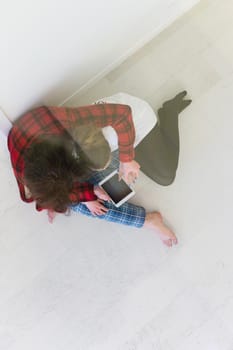 Young Couple sitting on the floor and using interent on digital tablet