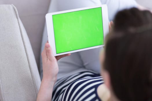 young happy woman on sofa using tablet computer at luxury home