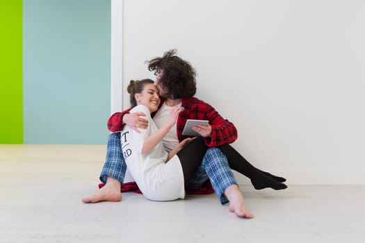 Young Couple sitting on the floor and using interent on digital tablet