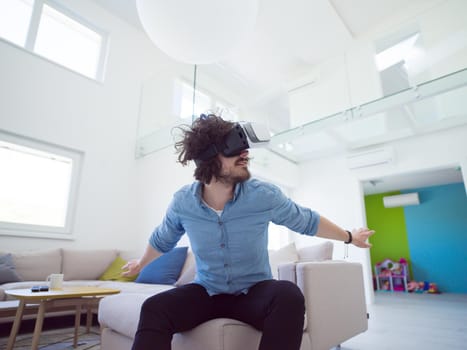 happy man getting experience using VR-headset glasses of virtual reality at home