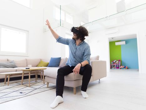 happy man getting experience using VR-headset glasses of virtual reality at home