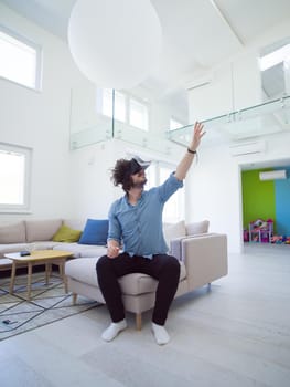 happy man getting experience using VR-headset glasses of virtual reality at home