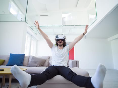 happy man getting experience using VR-headset glasses of virtual reality at home