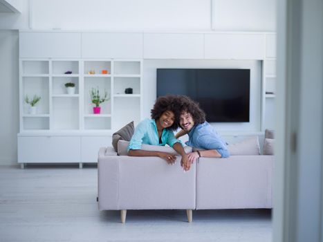 Young multiethnic couple sitting on a sofa in the luxury living room