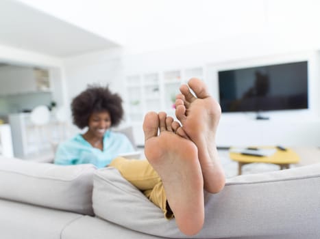 Young african american woman at home relaxing in her luxury lliving room reading a digital tablet  surf internet and work