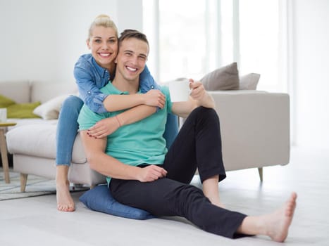 Portrait of a happy young beautiful couple hugging and drinking coffee in their new home