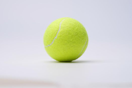 Bright lime tennis ball on white background. Choosing tennis ball to play concept