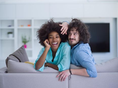 Young multiethnic couple sitting on a sofa in the luxury living room