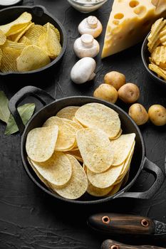 Variation different potato chips set, on black stone background