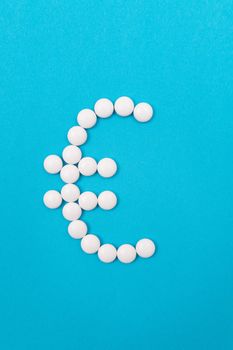 Global Pharmaceutical Industry and Medicine Business - Euro Symbol Made from White Pills Lying on Blue Background