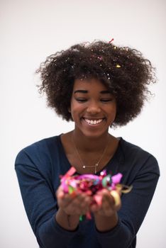 beautiful young black woman celebrating new year and chrismas party while blowing confetti decorations to camera