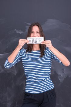 portrait of a young woman holding a banknote in front of chalk drawing board
