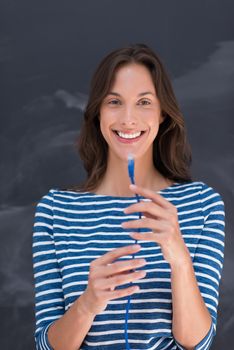 portrait of a young woman holding a internet cable in front of chalk drawing board