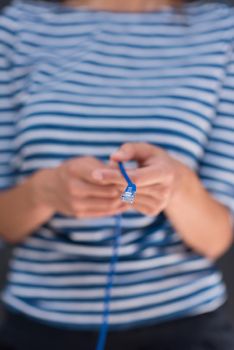 portrait of a young woman holding a internet cable in front of chalk drawing board