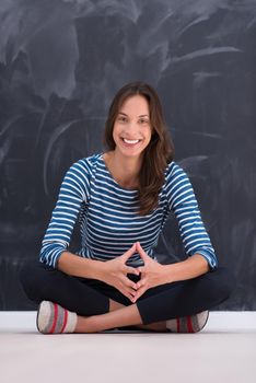 portrait of a young woman sitting in front of chalk drawing board
