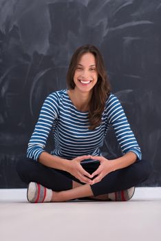 portrait of a young woman sitting in front of chalk drawing board