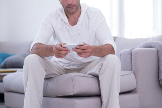 Handsome casual young man using a mobile phone at luxurious home