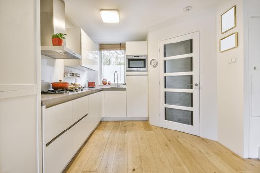 Cozy daylight kitchen with white cabinets and hardwood floors