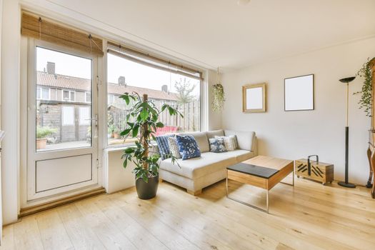 Cozy living area with a soft sofa with pillows and a large window in the back