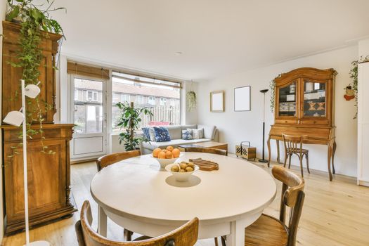 Cozy dining area with round wooden white table and chairs