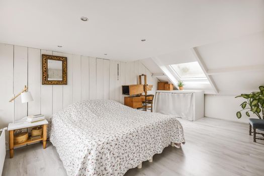 Cozy attic room with a fluffy bed covered with a blanket