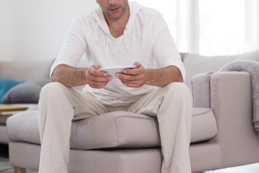 Handsome casual young man using a mobile phone at luxurious home