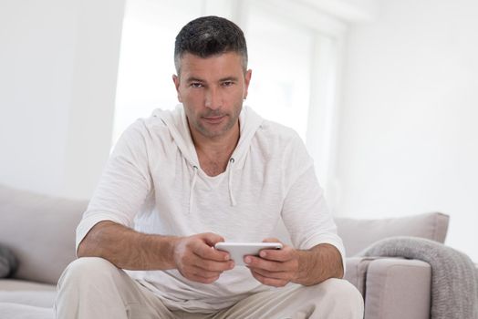 Handsome casual young man using a mobile phone at luxurious home