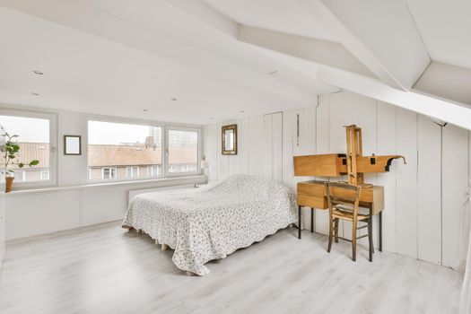 Cozy attic room with a fluffy bed covered with a blanket