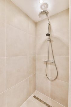 Beige bathroom with modern walk-in shower in a luxury apartment