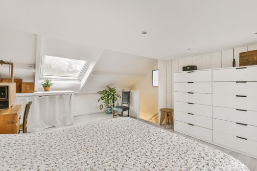 Cozy attic room with a fluffy bed covered with a blanket