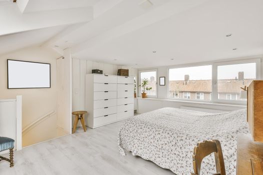 Cozy attic room with a fluffy bed covered with a blanket