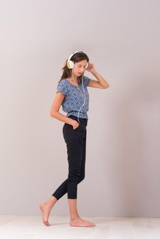 Happy young woman listening and enjoying music with headphones isolated on a white background