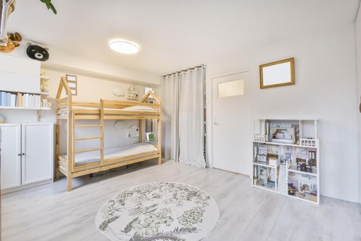 Cozy children's room with a two-story wooden bed and a round rug