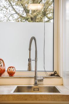 Cozy kitchen in daylight with a sink and decor on the windowsill