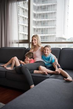 Happy Young Family Playing Together with tablet at home sitting on the sofa