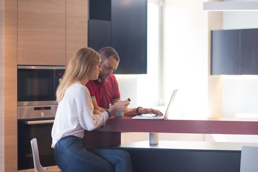 happy young couple buying online using laptop a computer and a credit card in their luxury home villa