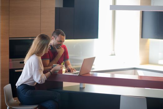 happy young couple buying online using laptop a computer and a credit card in their luxury home villa