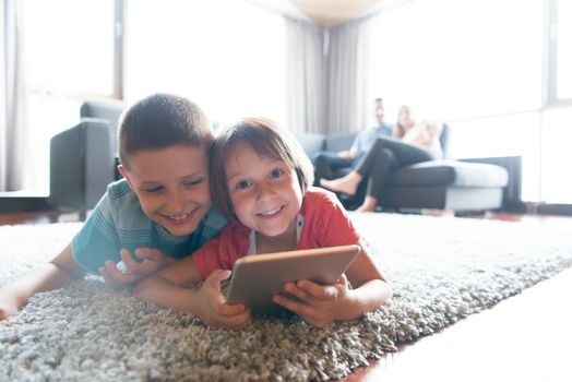 Happy Young Family Playing Together at home.kids using tablet on the floor